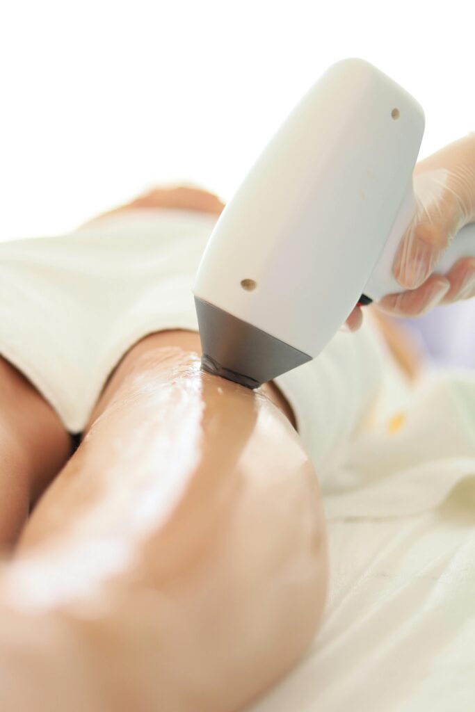 Close-up of laser hair removal on woman's leg in professional spa setting.